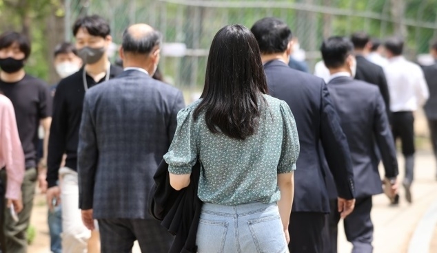 낮 기온이 27도까지 올라가며 여름 날씨를 보인 지난 22일 정오를 넘긴 시간 서울 여의도공원에서 시민이 외투를 벗어 팔에 걸친 채 산책을 즐기고 있는 모습. 사진=연합뉴스