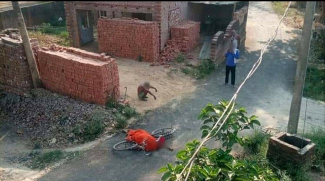인도의 한 노인이 코로나19로 사망한 아내의 시신을 자전거로 옮기다 힘에 부쳐 떨어뜨리고선 길가에 주저앉아 있다.  트위터 @manishtv9