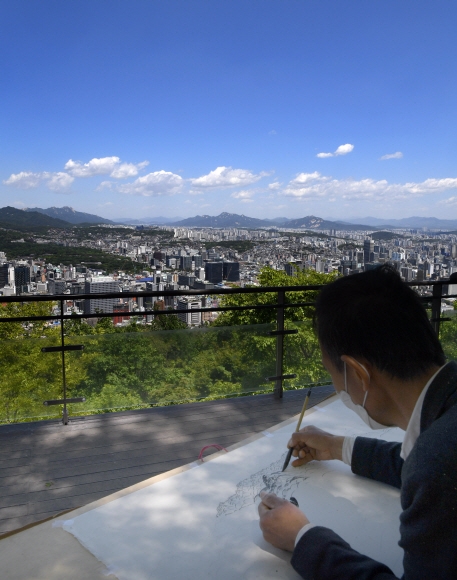 황사가 물러간 9일 서울 용산구 남산공원에서 건축가이자 화가인 김석환 씨가 파란 하늘을 배경으로 산 능선 그림을 그리고 있다. 2021.5.9 오장환 기자 5zzang@seoul.co.kr