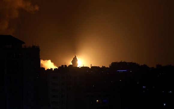 이스라엘의 공습으로 인한 포연이 10일(현지시간) 팔레스타인 가자지구의 밤하늘에 치솟고 있다. 하마스를 비롯한 팔레스타인 무장단체들이 100여발의 로켓을 쏘아올리자 이에 대한 보복으로 공습이 감행됐다. 가자 시티 AP 연합뉴스 