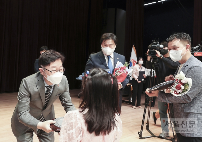 박범계(왼쪽) 법무부장관이 정왕동에 사는 중국인 귀화자인 서철규(47)씨 딸에게 대한민국 국적증서를 수여하고 있다.