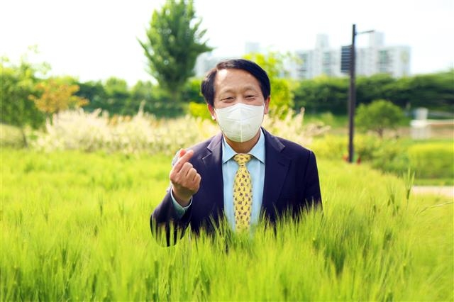 이성 서울 구로구청장이 지난 11일 다양한 꽃과 식물로 가득한 안양천 생태초화원을 둘러본 뒤 카메라 앞에 서 손가락 하트를 하고 있다. 구로구 제공