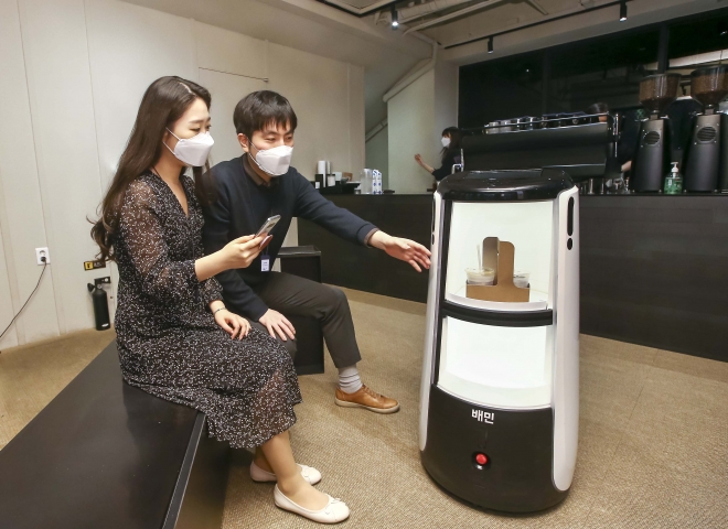 D타워 광화문에서 배달로봇 딜리타워를 이용해 커피 배달 서비스를 시연하고 있다. 우아한형제들·DL이앤씨 제공