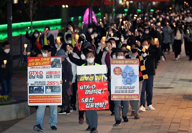 경기 김포와 인천 검단 주민들로 구성된 김포검단교통시민연대가 지난 8일 김포시 장기동 라베니체에서 GTX-D 노선의 서울 직결을 요구하며 촛불 행진을 하고 있다. 뉴스1