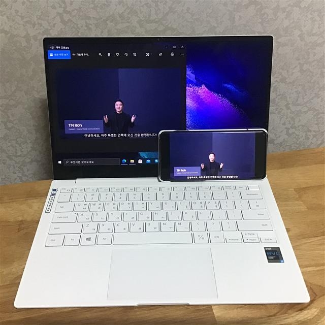 삼성전자의 신제품 ‘갤럭시북 프로’를 통해 노트북과 스마트폰에서 지난달 열린 ‘삼성 갤럭시언팩 2021’ 행사 캡처 화면을 주고받은 모습.
