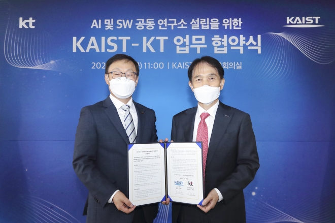 　구현모(왼쪽) KT 대표와 이광형 카이스트 총장이 지난 21일 대전 유성구 카이스트 본원에서 ‘인공지능(AI) 및 소프트웨어(SW) 공동연구소 설립을 위한 업무협약식’을 체결한 뒤 협약서를 함께 들어보이고 있다. 　KT 제공