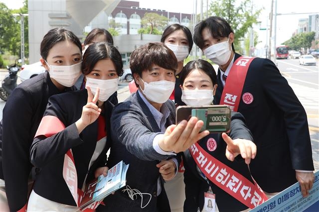 국민의힘 당 대표 경선에 출마한 이준석(가운데) 전 최고위원이 24일 대구 북구 경북대 북문 앞에서 대학생들과 인사를 나누며 셀카를 찍고 있다. 대구 뉴스1