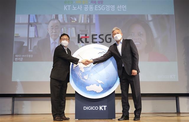 구현모(왼쪽) KT 대표와 최창복 KT 노동조합 위원장이 지난달 서울 종로구 KT스퀘어에서 열린 ‘노사 공동 ESG 경영선언식’에서 선언문에 서명한 뒤 악수를 하고 있다. KT 제공