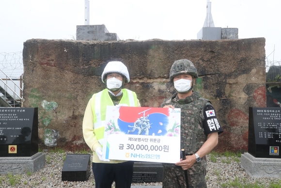 이성희 농협중앙회장(사진 왼쪽)이 3일 화살머리고지 유해발굴작전 현장에서 군부대의 노력을 응원하기 위해 이상철 5사단장에게 위문금을 전달하고 있다.