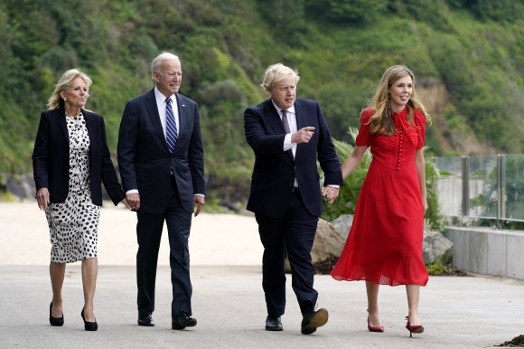 10일(현지시간) 영국 콘월 콘웨이 비치를 걷는 조 바이든 미국 대통령 내외(왼쪽)과 보리스 존슨 영국 총리 부부. AP