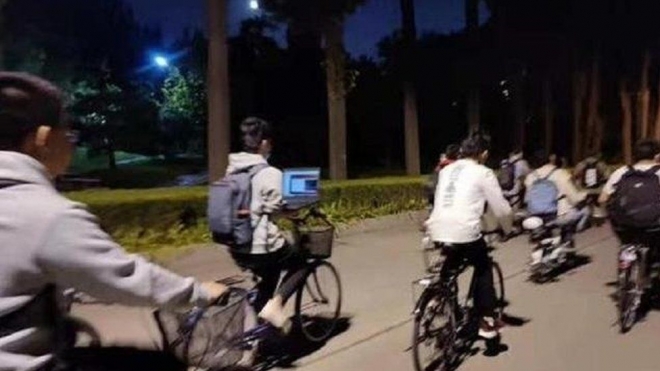 지난해 중국 인터넷을 발칵 뒤집은 화제의 사진. 칭화대 학생이 자전거를 타고 귀가하며 랩톱 컴퓨터를 견 채로 밀린 공부를 하고 있다. 이런 행위는 일부 젊은이들 사이에서 ‘쥐 경주’에 맹목적으로 빠져 있는 반증으로 여겨지고 있다. 웨이보 캡처