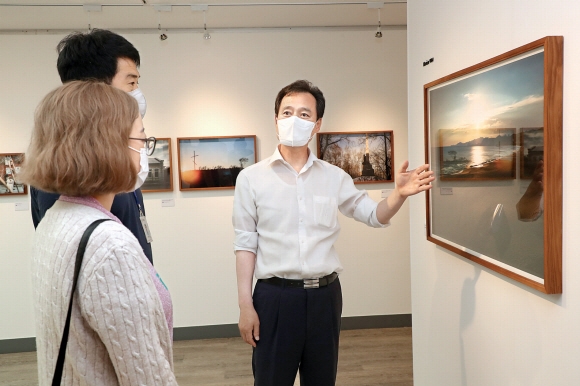 박겸수(오른쪽) 서울 강북구청장이 지난 10일 수유동 근현대사기념관에서 쿠바 한인 이주 100주년 기념 특별사진전 관람을 하는 직원들에게 사진에 관해 설명하고 있다. 강북구 제공