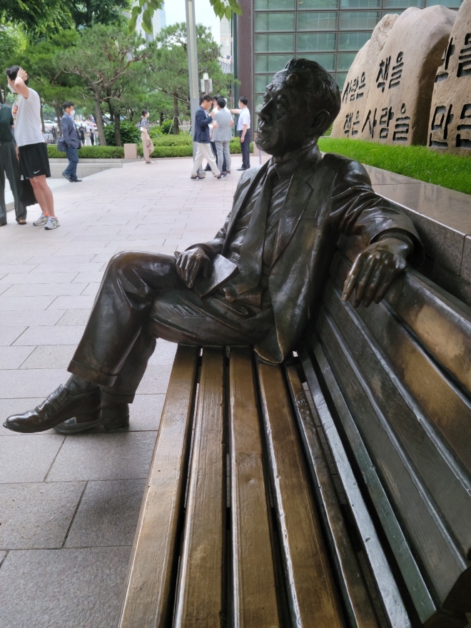 횡보 염상섭이 교보문고 광화문점 종로 출입구 벤치에 생각에 잠긴듯 앉아 있다.