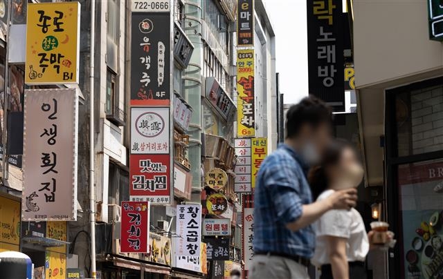 거리두기 개편… 자영업자 숨통 트일까  21일 서울 종로구 젊음의거리가 마스크를 쓰고 점심식사를 위해 발걸음을 옮기는 시민들로 붐비고 있다. 앞서 정부는 지난 20일 다음달부터 사적 모임 제한을 8명으로 늘리고 식당, 카페 등의 영업시간을 밤 12시까지 확대하는 사회적 거리두기 개편안을 발표했다. 뉴스1