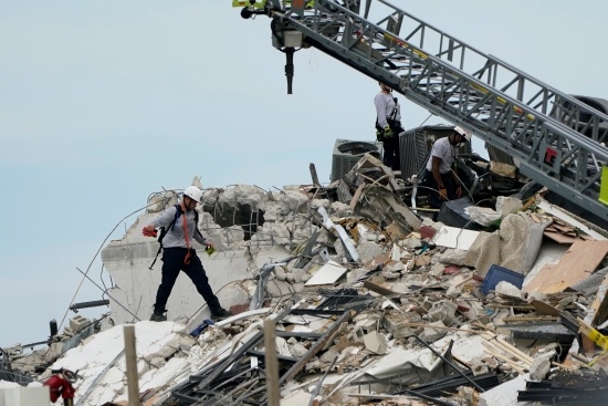 24일(현지기간) 미국 플로리다주 마이애미데이드카운티 서프사이드에서 발생한 12층 아파트 붕괴 현장에서 구조대가 건물 잔해를 헤치며 생존자를 찾고 있다. 로이터 연합뉴스
