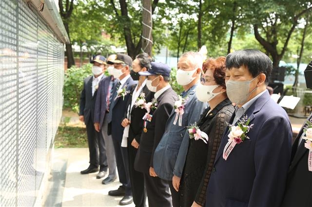 이성(오른쪽 첫 번째) 서울 구로구청장이 보훈단체 관계자들과 지난 23일 구로동 거리공원 내 참전유공자 기념비 앞에서 비석에 새겨진 구로구 출신의 호국 영웅들의 이름을 바라보고 있다. 구로구 제공