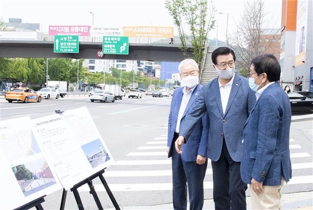 성장현(가운데) 서울 용산구청장이 지난 28일 한남오거리 보도육교 앞에서 주민들에게 육교 엘리베이터 설치 계획에 대해 설명하고 있다. 용산구 제공