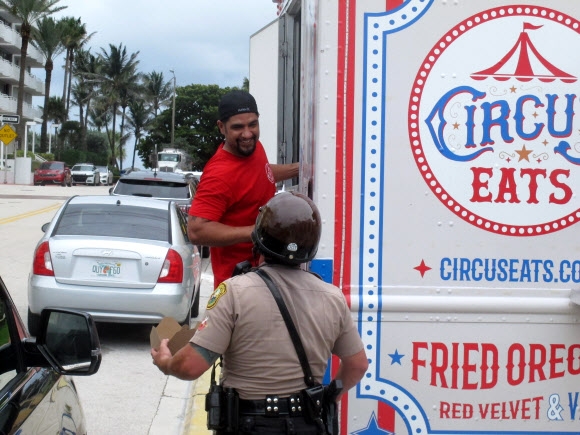 미국 플로리다주 서프사이드의 한 푸드트럭에서 29일(현지시간) 구조대원과 주인이 이야기를 나누고 있다. AP