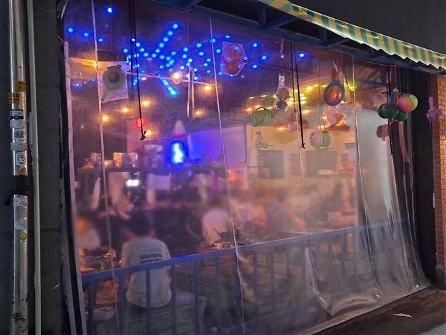 서울 마포구 홍대 원어민 강사 모임에서 시작된 코로나19 집단감염이 확산되는 가운데 지난달 30일 홍대 인근 한 술집에서 청년들이 술을 마시고 있다.