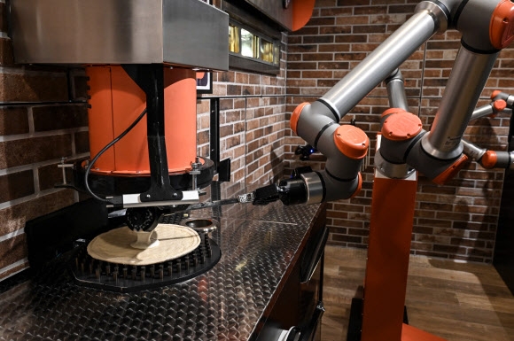 프랑스 레스토랑 주방서 일하는 피자 제조 로봇