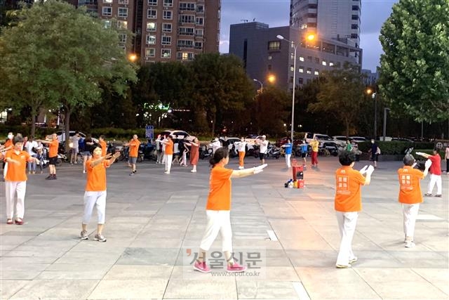 지난 3일 중국 베이징 왕징의 한 백화점 입구 광장에서 유니폼을 입은 중년 여성들이 광장무를 추고 있다.  베이징 류지영 특파원 superryu@seoul.co.kr