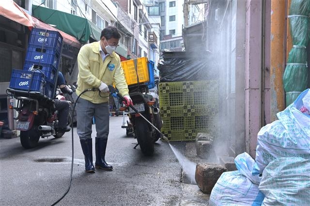 서양호 서울 중구청장이 취임 3주년을 맞은 지난 1일 황학시장 돼지 부산물 골목에서 고압살수기를 이용해 물청소하고 있다. 중구 제공