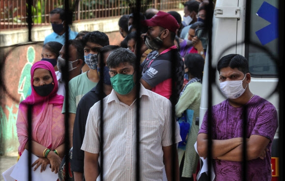 4일(현지시간) 인도 뭄바이의 한 접종센터 앞에서 시민들이 코로나19 백신 접종 순서를 기다리고 있다. 2021.7.4  AP 연합뉴스