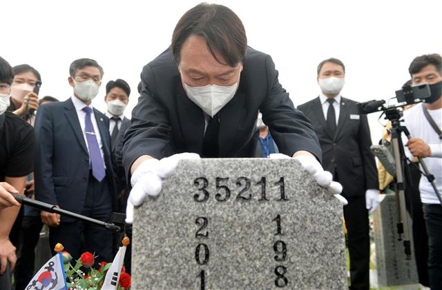 야권 대선주자인 윤석열 전 검찰총장이 6일 국립대전현충원을 방문해 천안함46용사 묘역을 찾아 참배한 뒤 묘비를 어루만지고 있다. 대전 뉴스1