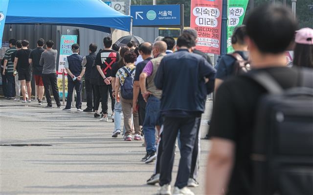 6일 오전 서울 중구 서울역광장에 마련된 임시선별진료소를 찾은 시민들이 검체검사를 받기 위해 줄을 서 있다.  2021.7.6 뉴스1