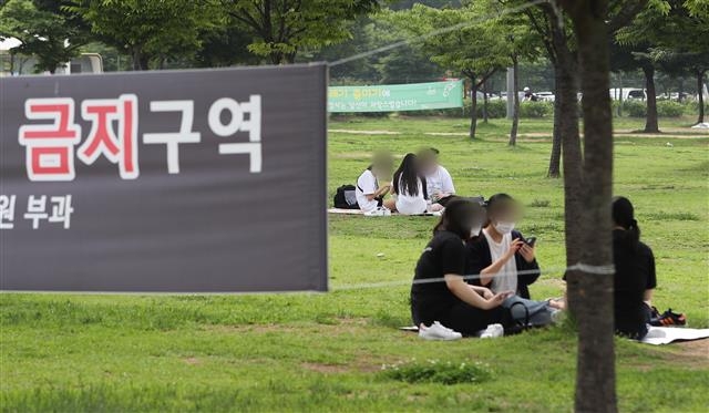 서울시의 밤 10시 이후 야외음주 금지 시행을 하루 앞둔 6일 서울 영등포구 여의도한강공원에서 시민들이 돗자리를 펴고 취식을 하고 있다. 2021.7.6 뉴스1