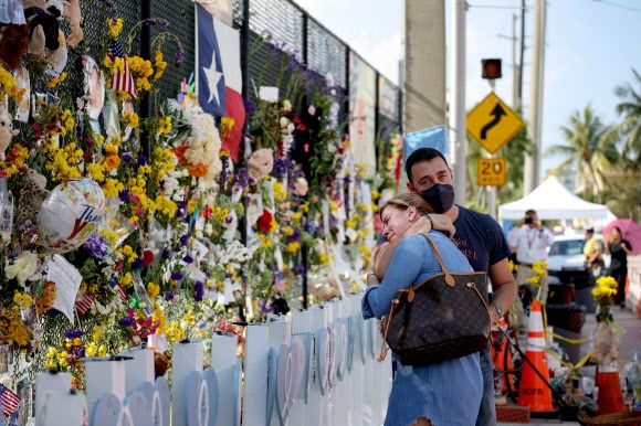 미국 플로리다주 12층 아파트 붕괴 사고 희생자들을 기리는 추모 공간 앞에서 8일(현지시간) 유족들이 슬퍼하고 있다. 2021.7.9  AFP 연합뉴스