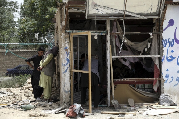 10일(현지시간) 아프가니스탄 카불에서 사람들이 폭탄에 맞은 가게를 들여다보고 있다. AP
