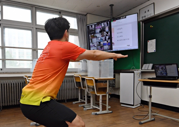 수도권 지역 사회적 거리두기가 4단계로 격상된 12일 경기도 분당구 정자중학교 내 교실에서 교사 이승권 씨가 원격으로 체육수업을 하고 있다. 2021.7.12 오장환 기자 5zzang@seoul.co.kr