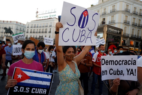 수도 아바나를 비롯해 산티아고, 산타클라라 등 쿠바의 주요 도시에서 시위가 일어나면서 국제적으로 동조 시위도 뒤따르고 있다. 스페인 마드리드 시민들이 12일(현지시간) ‘SOS 쿠바’ 등의 피켓을 들고 거리를 행진하고 있다. 마드리드 EPA 연합뉴스