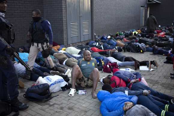 13일(현지시간) 남아프리카공화국 가우텡주 요하네스버그에서 제이콥 주마 전 대통령의 구금에 항의하며 방화와 약탈을 벌인 시위대가 경찰에 체포돼 바닥에 누워있다. 요하네스버그 EPA 연합뉴스