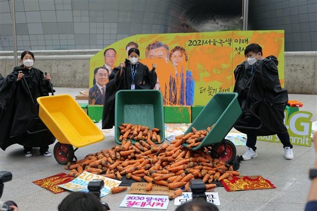 청소년기후행동은 정부와 기업들에 기후 위기에 대한 행동을 촉구하는 목소리를 꾸준히 내고 있다. 사진은 지난 5월 P4G 서울 녹색미래정상회의를 앞두고는 동대문디자인플라자에서 썩은 당근 217㎏을 쏟아부었다. 2030년까지 한국의 이산화탄소 배출량을 217Mt 아래로 줄여야 한다는 걸 의미한다.  청소년기후행동 제공