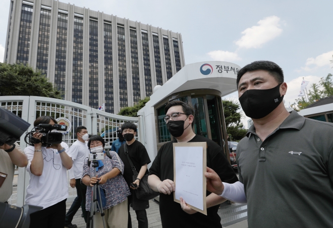 김기홍 코로나19 대응 전국자영업자비상대책위원회 대표 등이 16일 오후 서울 종로구 세종대로 정부서울청사 앞에서 거리두기 4단계 조치에 대한 자영업단체 입장문 발표 및 질의서 전달 1인 기자회견을 마친 뒤 국무총리실에 질의서를 전달하기 위해 이동하고 있다. 2021.7.16 뉴스1