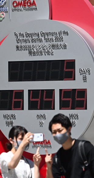 2020 도쿄올림픽을 5일 앞둔 18일 일본 도쿄역에 설치된 올림픽 개막 카운트다운 시계탑 앞에서 시민들이 사진을 찍고 있다. 2021.07.18 도쿄=올림픽사진공동취재단