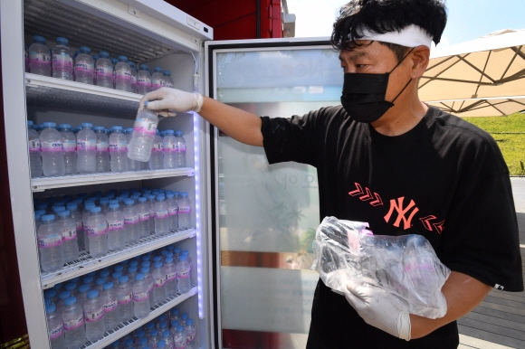 폭염이 계속되고 있는 21일 오전 관계자가 서울 노원구 불암산 나비정원에 마련된 냉장고에 생수를 채우고 있다. 누구나 이용 가능하다. 2021.7.21 도준석 기자 pado@seoul.co.kr