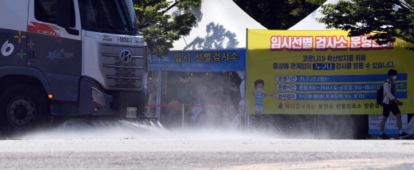 폭염이 계속되는 가운데 21일 서울 여의도공원 코로나19 임시선별진료소 앞으로 살수차가 지나가고 있다. 2021. 7. 21 박윤슬 기자 seul@seoul.co.kr