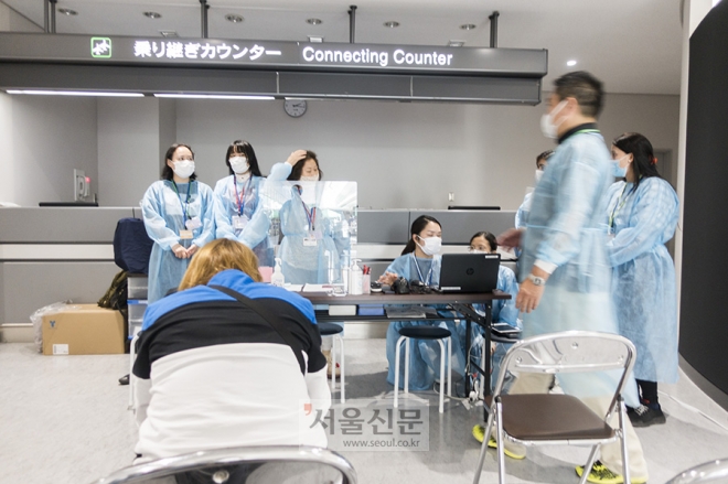 지난 20일 도쿄 나리타 공항에서 올림픽 필수앱인 ‘오차’에 문제가 생긴 사람들을 따로 격리한 공항 직원들이 안내 데스크에 서 있다. 도쿄 류재민 기자 phoem@seoul.co.kr
