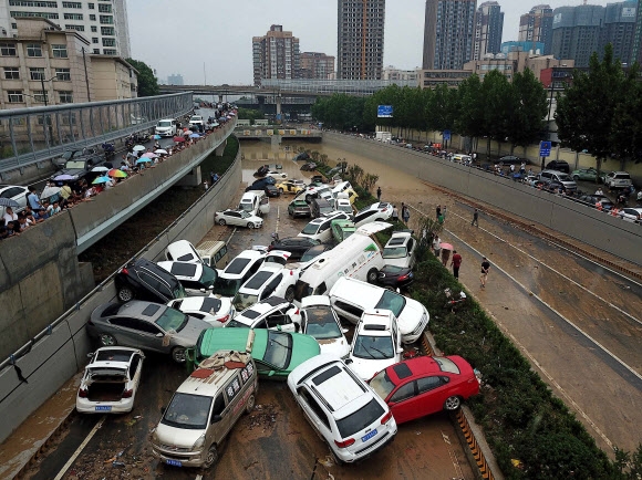 22일 중국 중부 허난성 도심 터널 입구에 이번 폭우로 침수된 차량들이 쌓여 있다. 정저우 AFP 연합뉴스