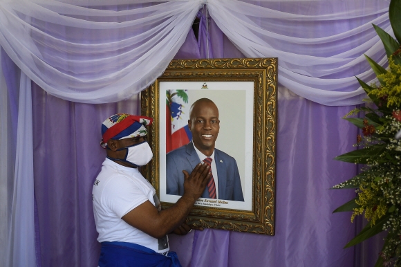 22일 아이티 캡아이티엔에서 한 남성이 성당에서 조브넬 모이즈 전 아이티 대통령의 영정을 만지고 있다.2021.7.23  사진=AP,