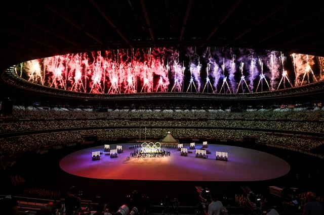 23일 일본 도쿄의 올림픽 스타디움(신국립경기장)에서 열린 ‘2020 도쿄올림픽’ 개회식에서 나무로 만든 오륜기가 등장하고 불꽃놀이가 진행되고 있다. 도쿄=올림픽사진공동취재단