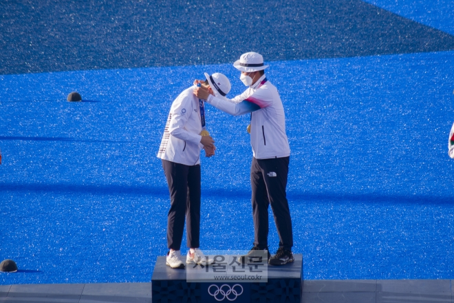 김제덕과 안산이 24일 일본 도쿄의 유메노시마공원 양궁장에서 열린 양궁 혼성 시상식에서 서로 금메달을 걸어주고 있다. 도쿄 류재민 기자 phoem@seoul.co.kr