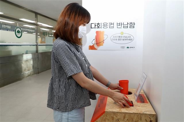 서울 강북구청 직원이 카페에서 가져온 다회용 공유컵을 회수함에 넣고 있다. 강북구 제공