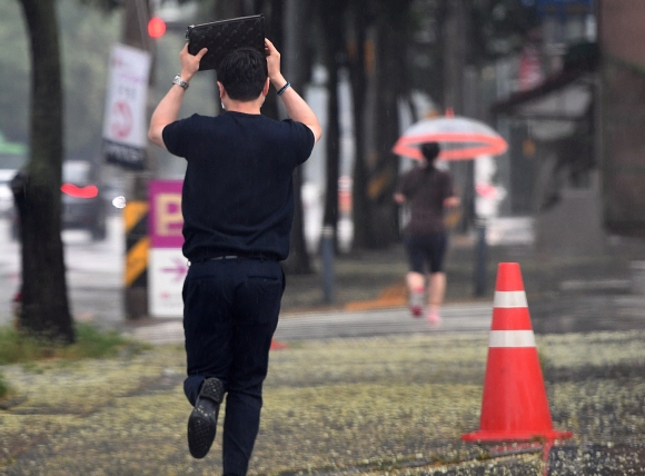 전국적으로 비가 내리는 1일 서울 시내에서 한 시민이 우산을 준비하지 못해 가방으로 비를 피하며 이동하고 있다. 2021.8.1 오장환 기자 5zzang@seoul.co.kr