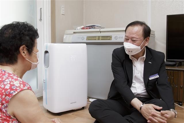 유동균(오른쪽) 마포구청장이 지난달 29일 이동형 에어컨이 설치된 한 어르신의 집에서 대화를 나누고 있다. 마포구 제공