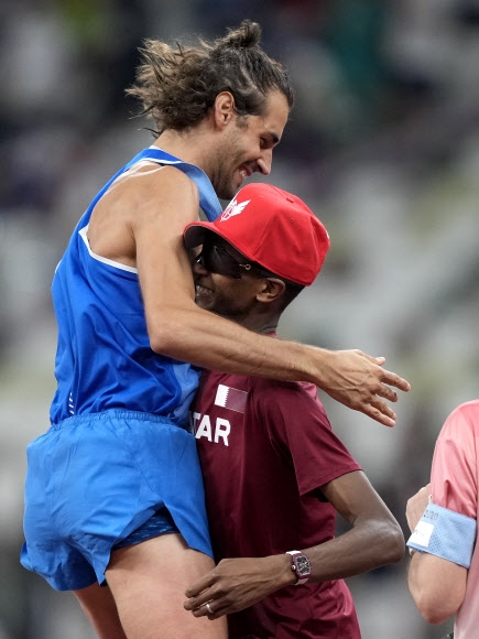장마르코 탐베리(왼쪽, 이탈리아)가 1일 2020 도쿄올림픽 육상 남자 높이뛰기 결선에서 2m37를 나란히 넘은 무타즈 바르심(카타르)과 우열을 가리기 어렵다고 판단해 공동 금메달로 만족하자고 제안하자 수락하며 둘이 자축하고 있다. 도쿄 AP 연합뉴스 