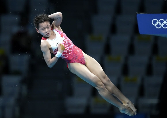 중국의 취안훙찬 선수가 5일 2020 도쿄올림픽 여자 다이빙 10m 플랫폼 파이널에서 완벽한 자세를 선보이며 만점을 획득하고 있다. AP 연합뉴스